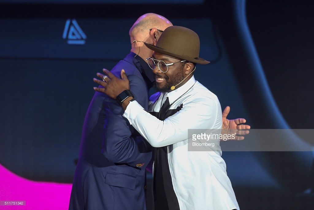 Timotheus Hoettges, chief executive officer of Deutsche Telekom AG, left, hugs Will.I.Am, musician-turned-entrepreneur, at the Telekom Unleashed event launching the Dial smartwatch at the Mobile World Congress in Barcelona, Spain, on Monday, Feb. 22, 2016. Mobile World Congress, an annual phone-industry event organized by GSMA Ltd., runs from Feb 22 to Feb 25. Photographer: Chris Ratcliffe/Bloomberg *** Local Caption *** Will.I.Am; Timotheus Hoettges
